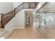 Bright foyer with wooden staircase, light wood floors, and a glass-enclosed office space at 9349 Russell Cir, Arvada, CO 80007