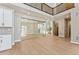 High-ceiling living room with glass-walled office and wooden staircase at 9349 Russell Cir, Arvada, CO 80007