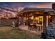 Inviting covered patio with wooden beams, string lights, and an outdoor dining area for memorable evening gatherings at 748 S Grape St, Denver, CO 80246