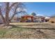 Expansive backyard featuring a covered patio, dining set, brick house, and mature trees at 748 S Grape St, Denver, CO 80246