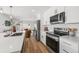 Modern kitchen with white cabinets, stainless steel appliances, and quartz countertops open to the living room at 1337 N Alton St, Aurora, CO 80010
