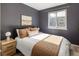 Bedroom featuring dark grey walls, hardwood floors, a comfortable bed, and bright natural lighting at 3251 N Madison St, Denver, CO 80205