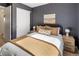 Bedroom featuring dark grey walls, hardwood floors, a comfortable bed, and a closet at 3251 N Madison St, Denver, CO 80205