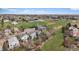 Aerial view of a neighborhood with lush greenery, homes, and a nearby open field at 10624 W Berry Pl, Littleton, CO 80127
