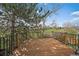 Wood back deck with black metal railing with an open green space in the background at 10624 W Berry Pl, Littleton, CO 80127