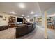 Spacious finished basement with a large sectional sofa, TV and a sliding glass door leading outside at 10624 W Berry Pl, Littleton, CO 80127