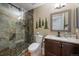 Updated bathroom featuring a tiled shower with glass doors, vanity, and charming woodland decor at 10624 W Berry Pl, Littleton, CO 80127