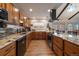 Spacious kitchen with wooden cabinets, stone counters and backsplash, and modern stainless steel appliances at 10624 W Berry Pl, Littleton, CO 80127