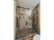 Tiled shower with decorative stone floor, glass door, rainfall shower head and built-in niche at 10624 W Berry Pl, Littleton, CO 80127