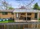Back exterior with patio, grill, seating, and manicured lawn enclosed by a wood fence at 5485 S Lakeview St, Littleton, CO 80120