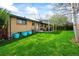 Backyard view of a brick home with a lawn and covered patio, offering an outdoor living space at 5485 S Lakeview St, Littleton, CO 80120