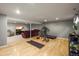 Well-lit basement with hardwood floors, gym equipment, and living area, perfect for recreation and relaxation at 5485 S Lakeview St, Littleton, CO 80120