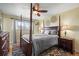Cozy bedroom features a four-poster bed, ceiling fan, and natural light from the window at 5485 S Lakeview St, Littleton, CO 80120