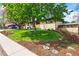 Landscaped front yard with lush lawn, mature trees, and a charming brick home at 5485 S Lakeview St, Littleton, CO 80120