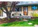 Charming brick home featuring a bench on the porch and a beautifully landscaped front yard with colorful flowers at 5485 S Lakeview St, Littleton, CO 80120