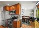 Kitchen with stainless steel appliances flows seamlessly into the dining area with hardwood floors at 5485 S Lakeview St, Littleton, CO 80120