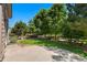 Beautiful backyard with a concrete patio, lush green lawn, and privacy provided by mature trees and wooden fence at 13794 E Caley Dr, Englewood, CO 80111