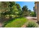 Serene backyard featuring a green lawn, a wooden fence, and mature trees offering privacy and a natural setting at 13794 E Caley Dr, Englewood, CO 80111
