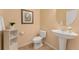 Bright powder room with pedestal sink, white cabinets, and decorative accents, creating a clean and welcoming space at 13794 E Caley Dr, Englewood, CO 80111