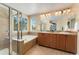 Luxurious bathroom with a glass-enclosed shower, soaking tub, dual sinks, and ample natural light, offering a spa-like experience at 13794 E Caley Dr, Englewood, CO 80111