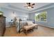 Comfortable bedroom featuring a tray ceiling, blue walls, and a large window, offering a serene retreat at 13794 E Caley Dr, Englewood, CO 80111