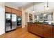 Well-lit kitchen featuring stainless steel appliances, light wood cabinets, and an island with a dark countertop at 13794 E Caley Dr, Englewood, CO 80111