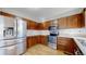 Well-lit kitchen featuring stainless steel appliances, warm cabinetry, and ample counter space at 1180 S Troy St, Aurora, CO 80012