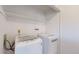 Bright laundry room featuring a modern washer and dryer set and overhead shelving at 1180 S Troy St, Aurora, CO 80012