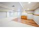 Finished basement area featuring a wet bar, laminate flooring, and neutral carpeting and paint at 9630 W La Salle Ave, Lakewood, CO 80227