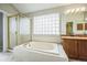 Bright bathroom features a soaking tub, tiled shower and vanity at 9630 W La Salle Ave, Lakewood, CO 80227
