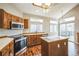 Spacious kitchen with wood cabinetry, an island, and stainless steel appliances at 9630 W La Salle Ave, Lakewood, CO 80227