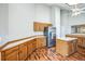 Eat-in kitchen with wood cabinetry, island, stainless steel refrigerator, and wood floors at 9630 W La Salle Ave, Lakewood, CO 80227