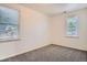 Bright bedroom with neutral carpet, white walls, and two windows providing plenty of natural light at 1390 Estes St, Lakewood, CO 80215