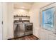 Functional laundry area with new washer and dryer, shelving for storage, and access to the backyard at 1390 Estes St, Lakewood, CO 80215