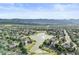 Community aerial view showcasing houses surrounding a large lake with fountain and mountain backdrop at 7720 Brown Bear Way, Littleton, CO 80125
