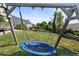 Backyard featuring a large trampoline swing surrounded by lush green grass and trees at 7720 Brown Bear Way, Littleton, CO 80125