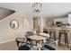 Cozy dining area with a round table and modern light fixture, adjacent to a kitchen with stainless steel appliances at 7720 Brown Bear Way, Littleton, CO 80125