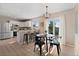 Cozy dining area with a round table and modern light fixture, adjacent to a kitchen with stainless steel appliances at 7720 Brown Bear Way, Littleton, CO 80125