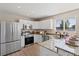 Bright kitchen features stainless appliances, granite countertops, and white cabinetry at 7720 Brown Bear Way, Littleton, CO 80125