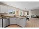 A bright kitchen with granite countertops, white cabinets and stainless dishwasher flows into the dining area at 7720 Brown Bear Way, Littleton, CO 80125