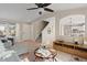 Open-concept living room with a staircase, ceiling fan, and hardwood floors, seamlessly connecting to dining area at 7720 Brown Bear Way, Littleton, CO 80125