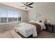 Inviting main bedroom featuring a ceiling fan, large window, and a cozy bench at 7720 Brown Bear Way, Littleton, CO 80125