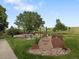 Entrance to Airplane Park in a green space featuring a large shade tree, playground and benches at 7720 Brown Bear Way, Littleton, CO 80125