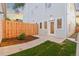 Well-maintained backyard with a wooden fence, grassy area, and patio entrance into the house at 1052 N Knox Ct, Denver, CO 80204