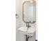 Stylish powder room features a wall-mounted sink, vintage faucet, and a decorative wood-framed mirror at 1052 N Knox Ct, Denver, CO 80204