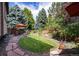 Backyard patio with landscaping, dining seating, and mature trees at 8316 Green Island Cir, Lone Tree, CO 80124