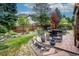 Paver patio with outdoor seating, lush landscaping, and serene water feature at 8316 Green Island Cir, Lone Tree, CO 80124