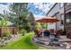 Professionally landscaped backyard with stone patio, umbrella, seating, and lush plants at 8316 Green Island Cir, Lone Tree, CO 80124