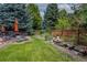 Tranquil backyard featuring lush landscaping, mature trees, and a serene water feature at 8316 Green Island Cir, Lone Tree, CO 80124