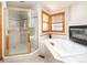 Bright bathroom boasts a separate shower, soaking tub and a cozy fireplace at 8316 Green Island Cir, Lone Tree, CO 80124